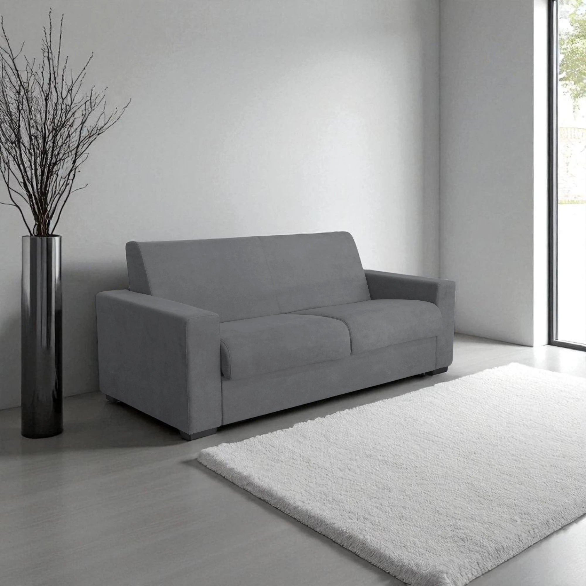 Il divano letto trasformabile in tessuto grigio con materasso integrato. Design moderno, materasso confortevole 140x190 cm e tessuto resistente. Perfetto per ogni ambiente.
