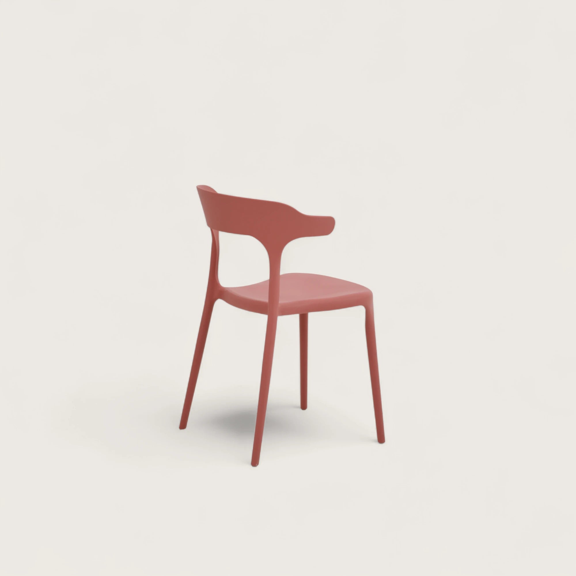 Sedia Katie in polipropilene terracotta, impilabile, con seduta curva e schienale sagomato con sporgenze laterali, design moderno per interni ed esterni.