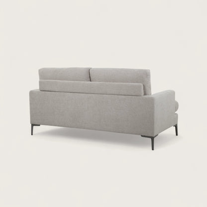 Il divano 2 posti è rivestito in tessuto crema, con una seduta ampia completata da due cuscini pieni. Il design moderno, linee pulite e piedini in metallo conferiscono stabilità e un tocco di stile contemporaneo, rendendo il divano adatto a soggiorni eleganti e funzionali.