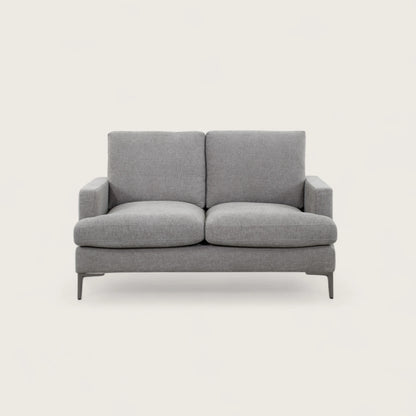 Divano 2 posti tortora in tessuto di alta qualità, con seduta ampia e due cuscini pieni. Design moderno con linee pulite e piedini in metallo per stile e stabilità.