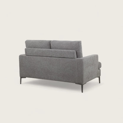 Divano 2 posti tortora in tessuto di alta qualità, con seduta ampia e due cuscini pieni e schienale alto. Design moderno con linee pulite e piedini in metallo per stile e stabilità.