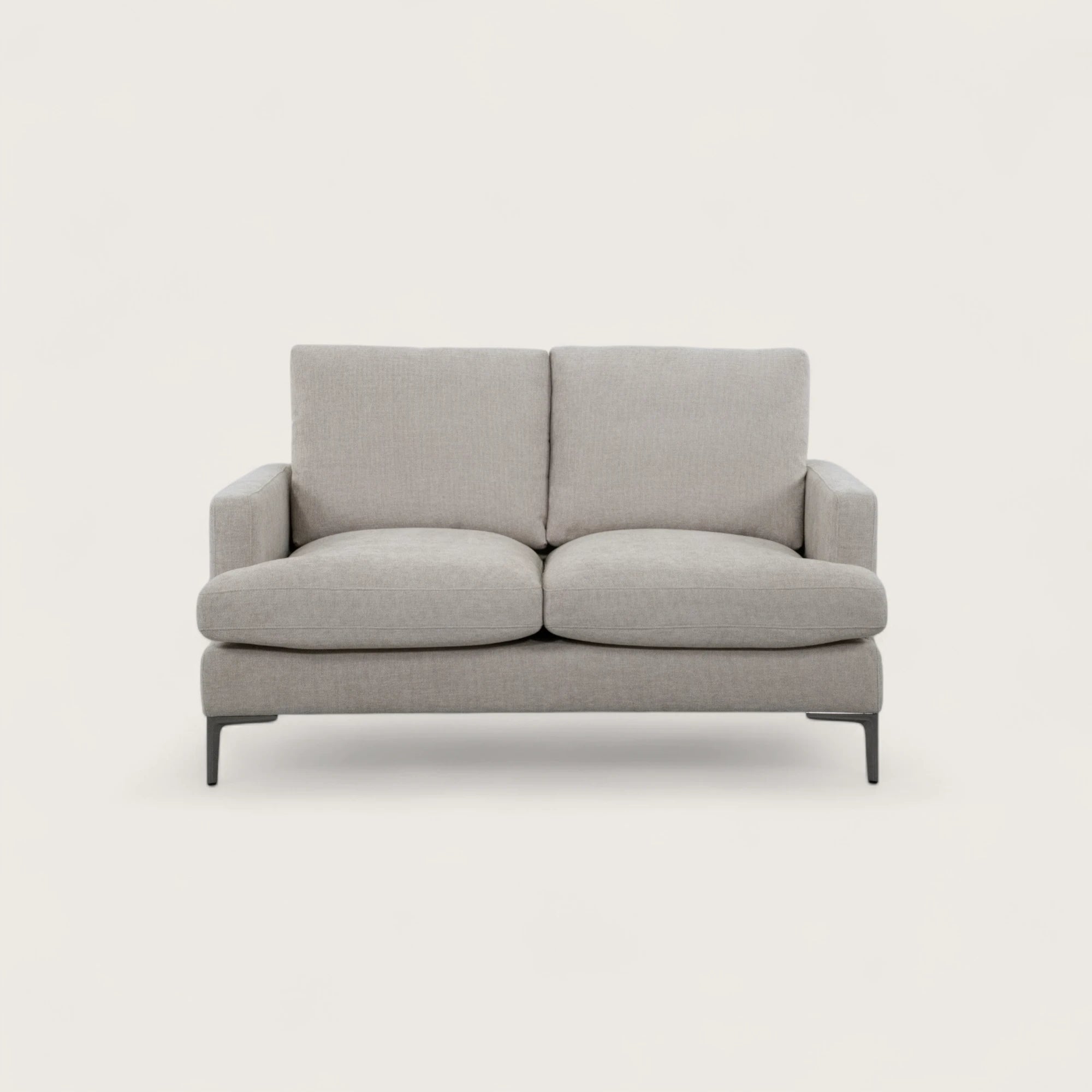 Divano 2 posti colore crema in tessuto di alta qualità, con seduta ampia e due cuscini pieni. Design moderno con linee pulite e piedini in metallo per stile e stabilità.