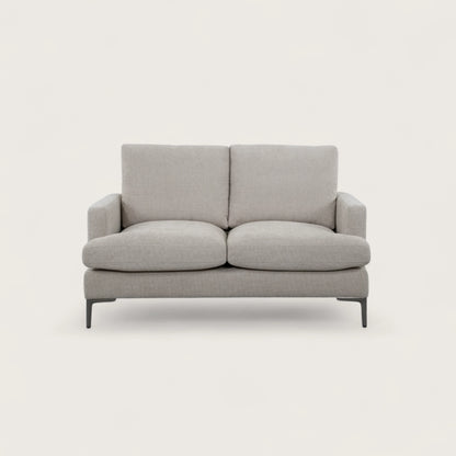 Divano 2 posti colore crema in tessuto di alta qualità, con seduta ampia e due cuscini pieni. Design moderno con linee pulite e piedini in metallo per stile e stabilità.