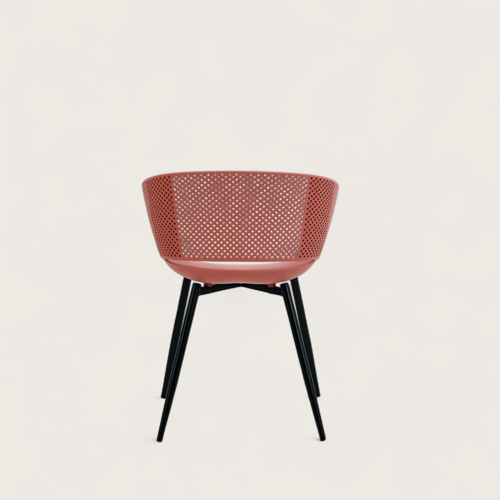 Sedia con scocca in polipropilene colore terracotta, schienale avvolgente  e gambe in metallo nero opaco, ideale per sale da pranzo, cucine e spazi contract.