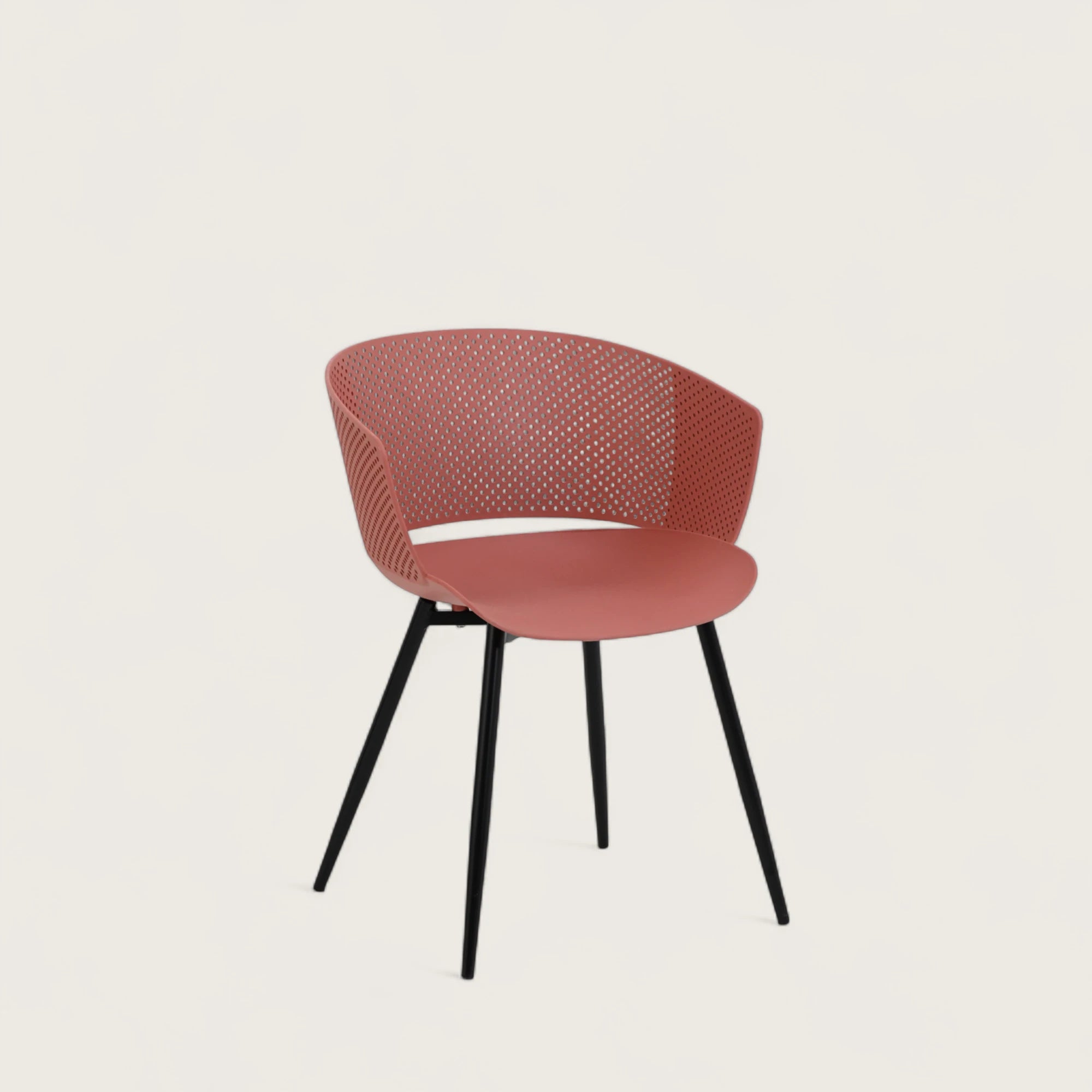 Sedia con scocca in polipropilene colore terracotta, schienale avvolgente  e gambe in metallo nero opaco, ideale per sale da pranzo, cucine e spazi contract.