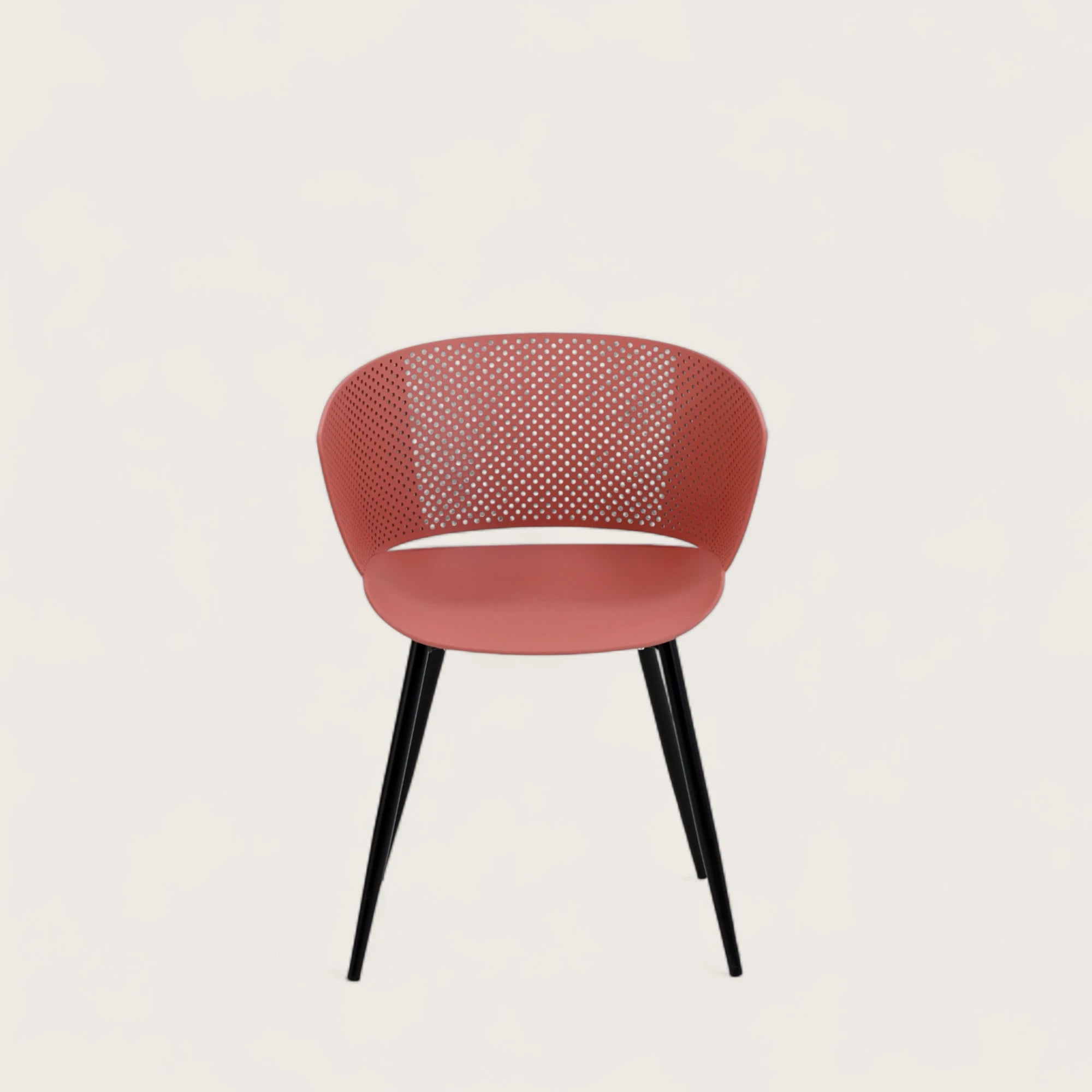 Sedia con scocca in polipropilene colore terracotta, schienale avvolgente  e gambe in metallo nero opaco, ideale per ambienti interni.